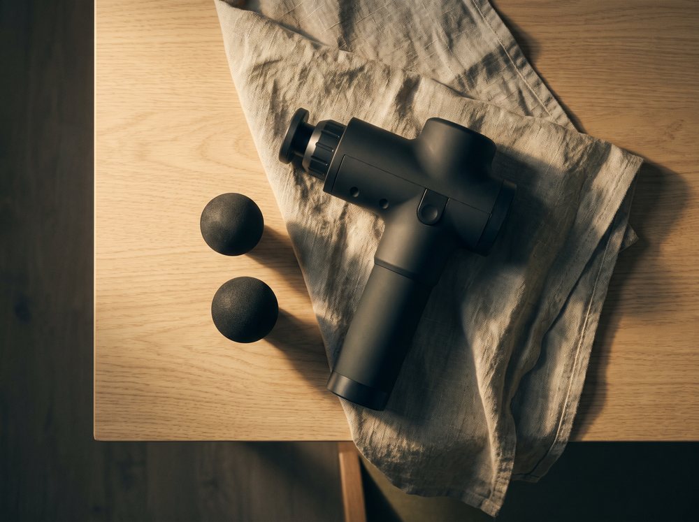 Percussion massage gun and attachments on a linen cloth