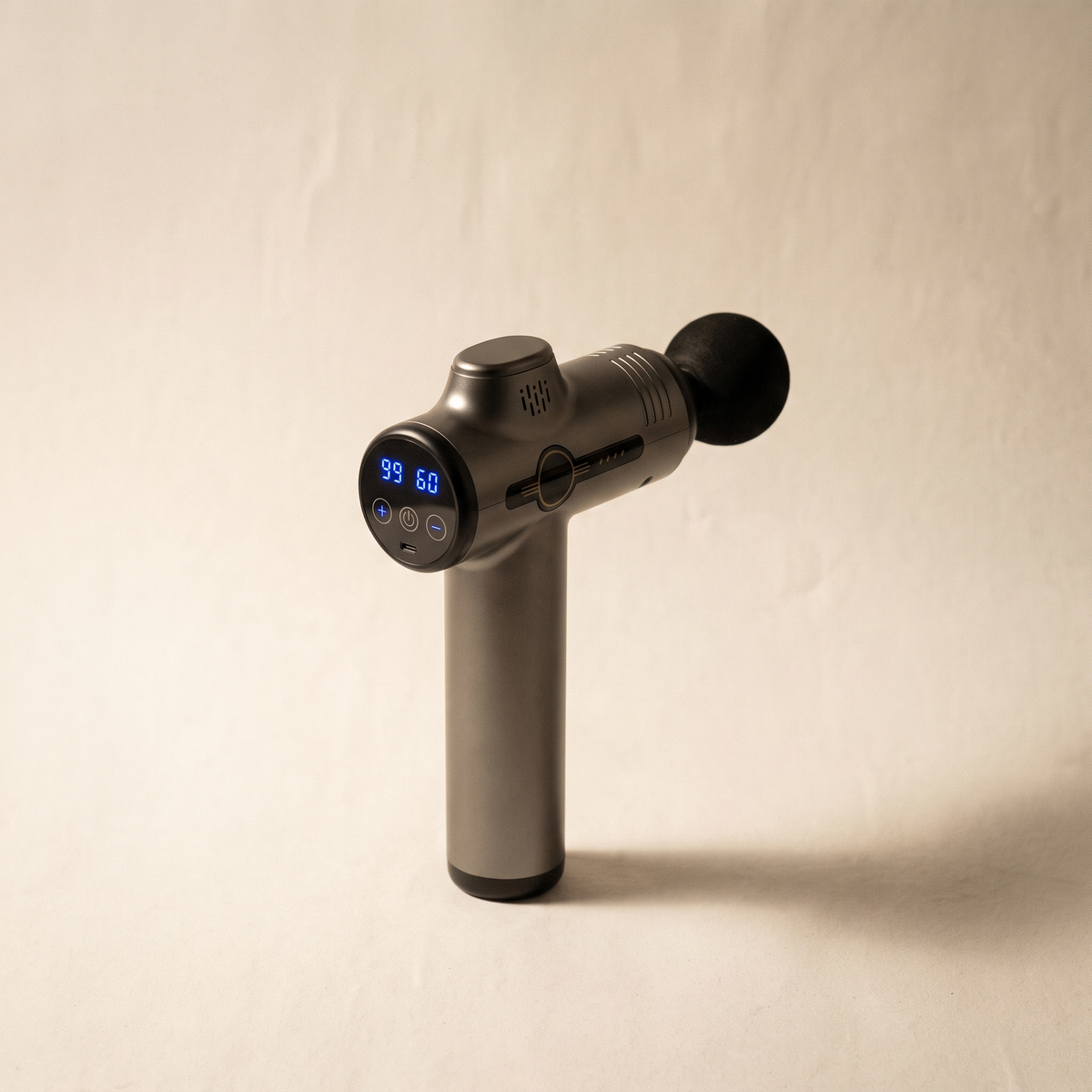 Four-head percussion massager on a warm off-white surface