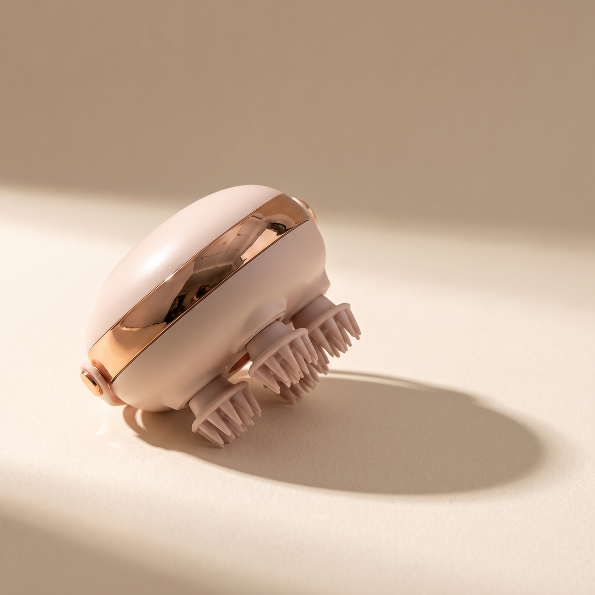 Scalp massager on a warm off-white surface