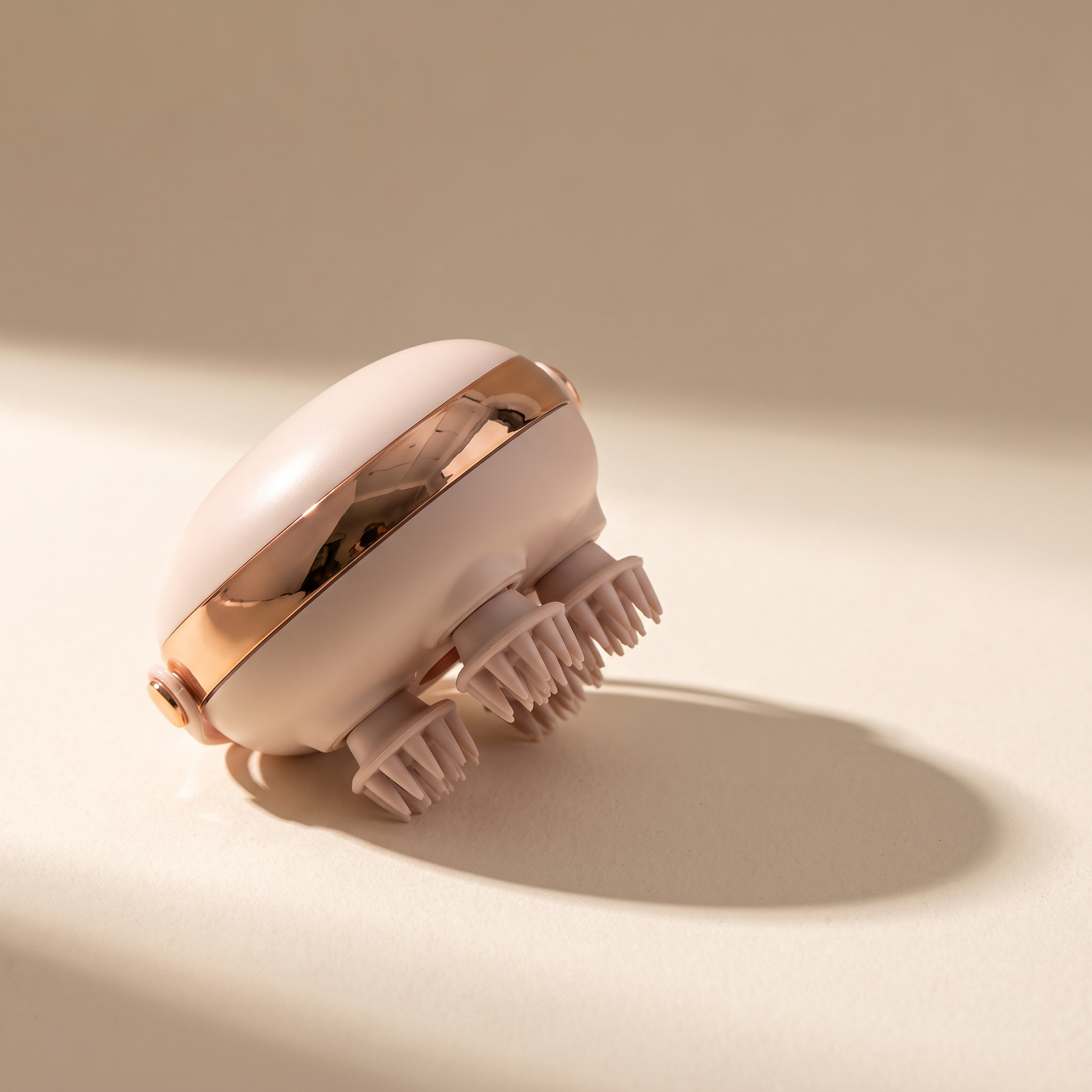 Scalp massager on a warm off-white surface
