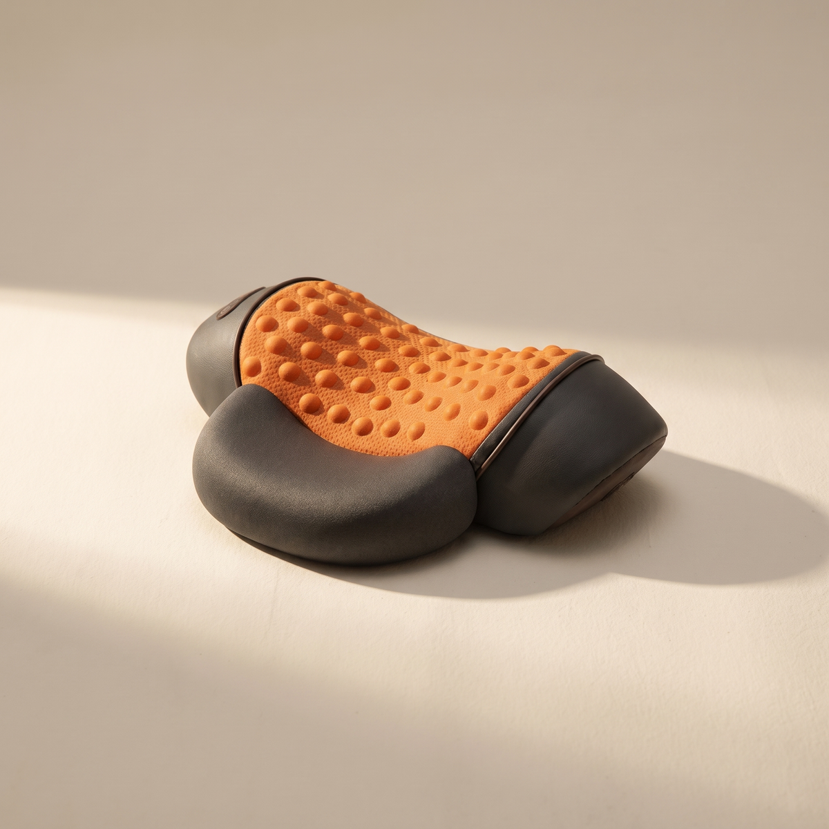 Heated shiatsu pillow on a warm off-white surface